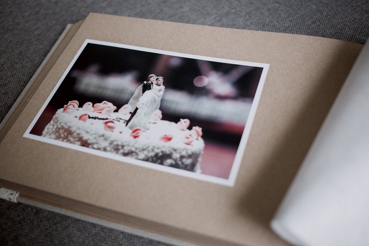 Artistic wedding photo in an album, showcasing cake topper details and romantic atmosphere.
